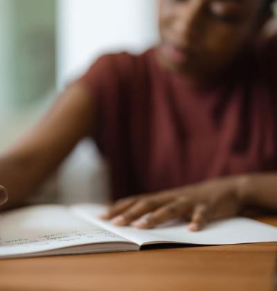 Young Black woman immersed in writing.