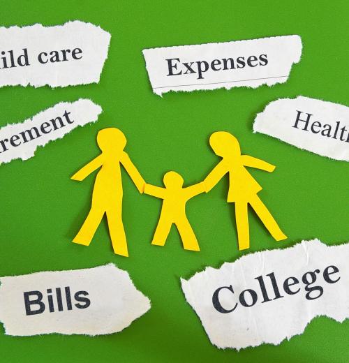 Paper family cut out with expenses on torn paper scraps.