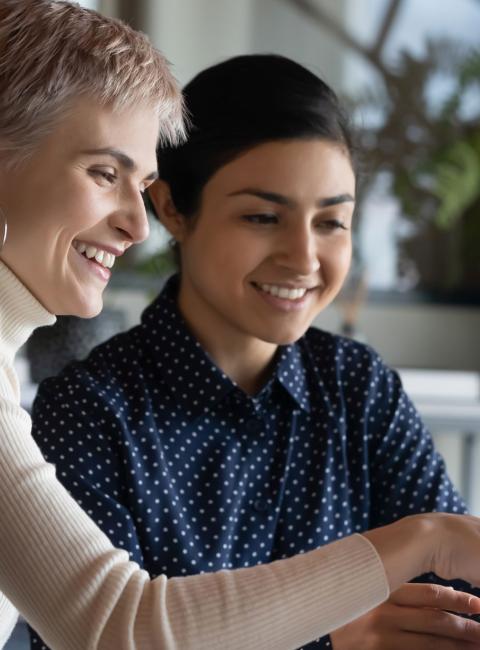 Two colleagues talking and looking at a computer.
